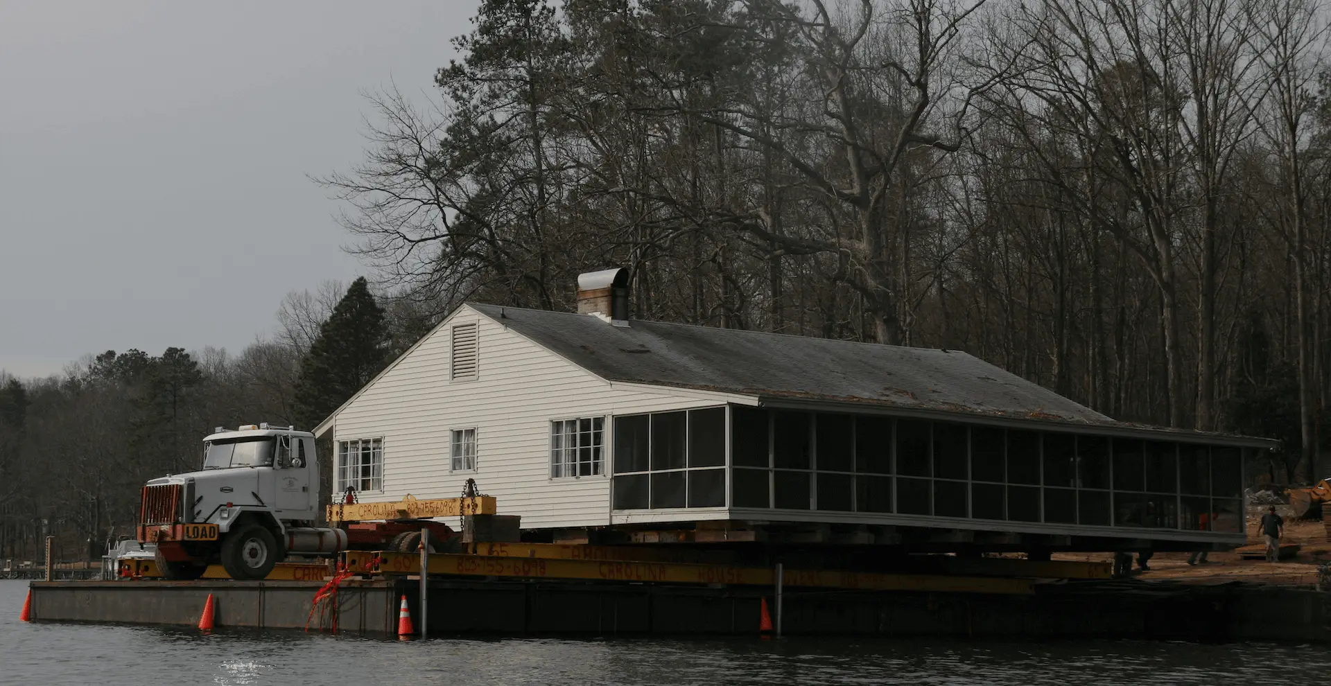 House being moved by barge across a South Carolina lake
